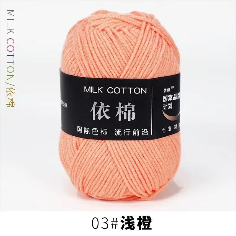 A ball of soft peach colored milk cotton yarn labeled 03# 浅橙, ready for knitting or crochet.