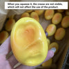 A hand holds a yellow squishy cheese cake stress relief toy against a background of similar items.