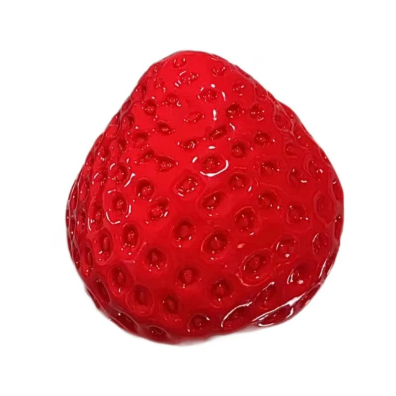 A bright red strawberry squeeze fidget toy with a glossy, textured surface.