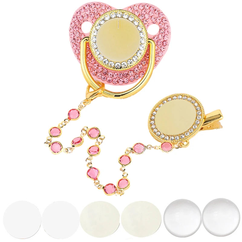 A pink baby pacifier and clip set with rhinestone accents displayed on a white background.