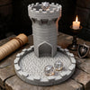 A gray medieval castle dice tower with a tray holding several polyhedral dice on a rustic wooden surface.