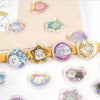 A collection of heart-shaped crystal stickers featuring cute, stylized animals and pastel colors on a light brown background.