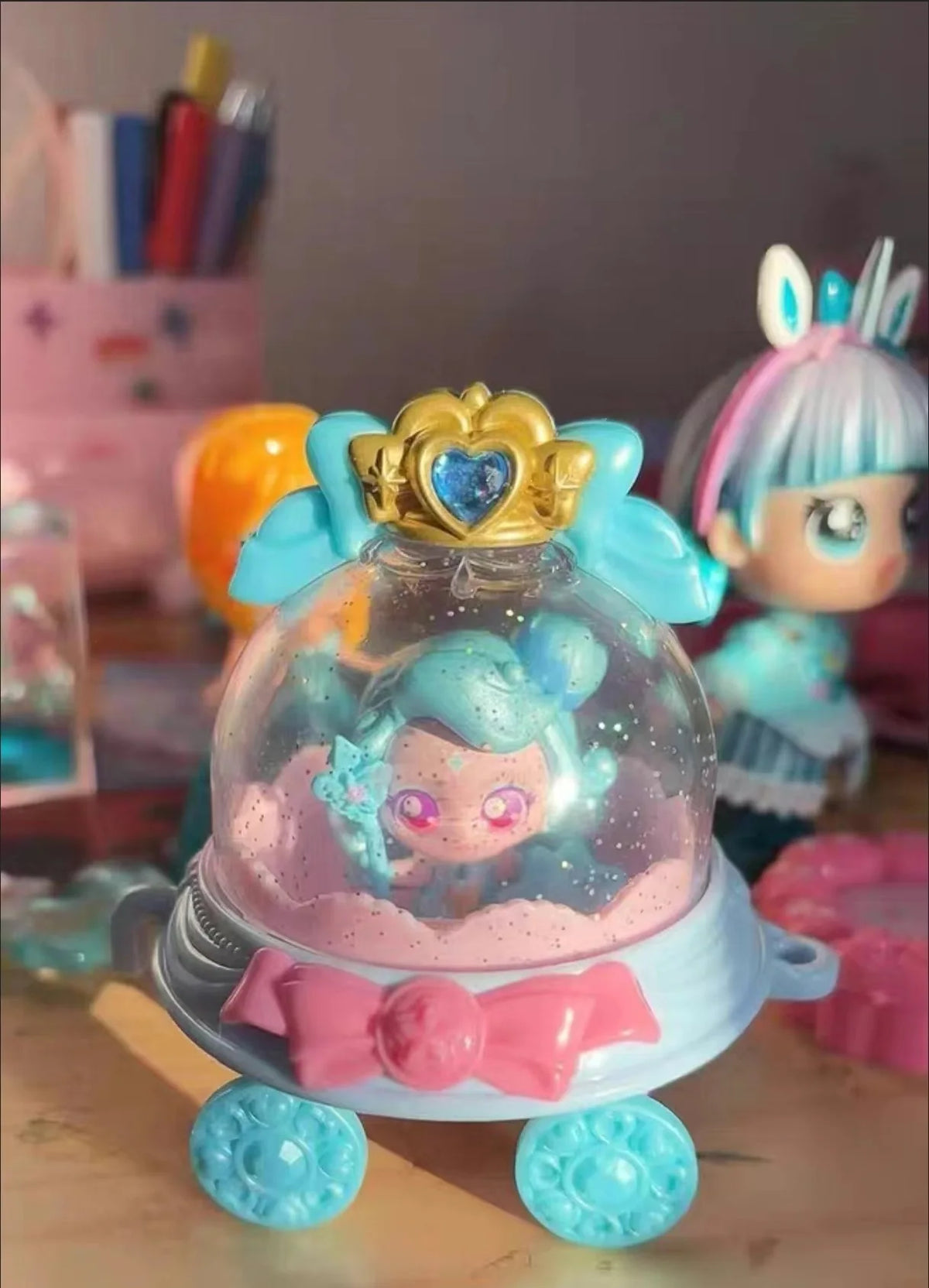 A close-up of a Teenieping Shining Meteor Aurora doll with light blue hair and a gold heart crown.