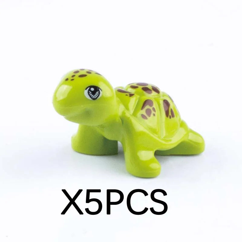 Five small green plastic marine animal building blocks including a shark or turtle shape.