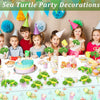 Sea turtle party decorations featuring plush toys, colorful balloons, and themed tableware for a children's party.