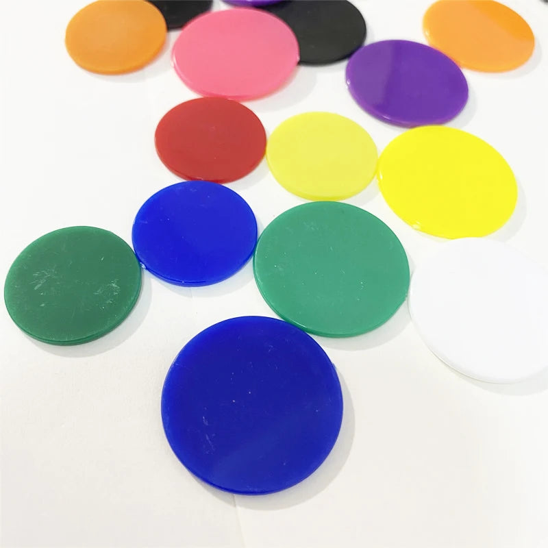 A collection of colorful plastic game markers in various shades including orange, pink, purple, yellow, red, and blue.