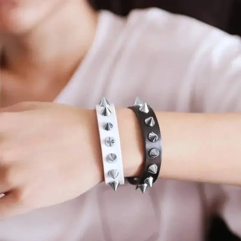 A close-up of a wrist wearing silver punk cone spike rivets for DIY fashion accessories.