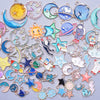 Assortment of gold-tone enamel charms featuring celestial bodies like moons stars planets and other shapes for jewelry making