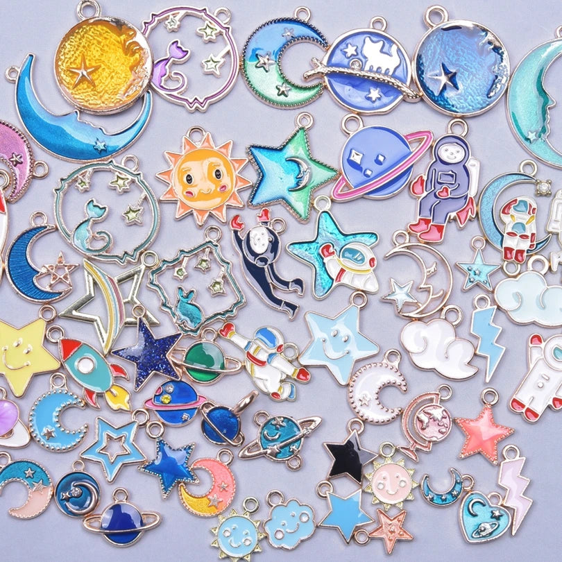 Assortment of gold-tone enamel charms featuring celestial bodies like moons stars planets and other shapes for jewelry making