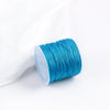 A roll of bright turquoise blue cotton nylon macrame cord for jewelry making and crafts.