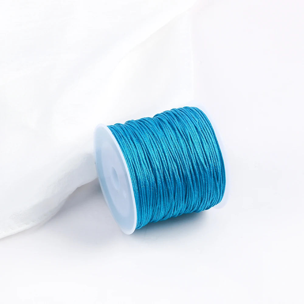 A roll of bright turquoise blue cotton nylon macrame cord for jewelry making and crafts.