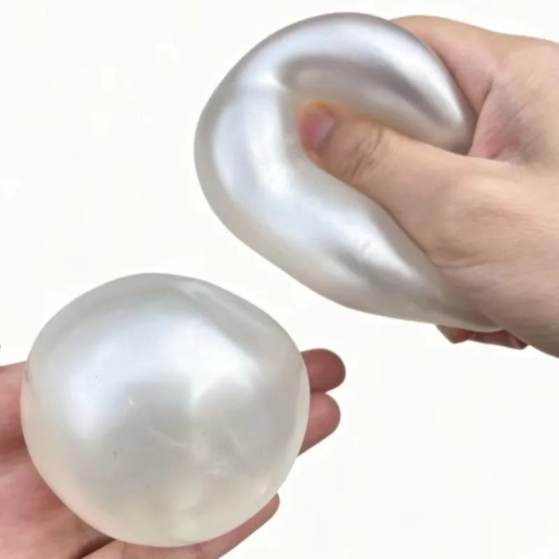 A hand is holding a smooth, translucent white squishy stress ball shaped like a spiral.