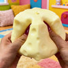 A hand is squeezing a large, yellow cheese-shaped squishy fidget toy.