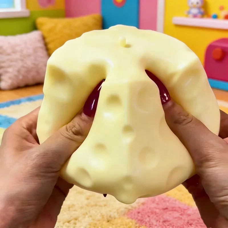 A hand is squeezing a large, yellow cheese-shaped squishy fidget toy.