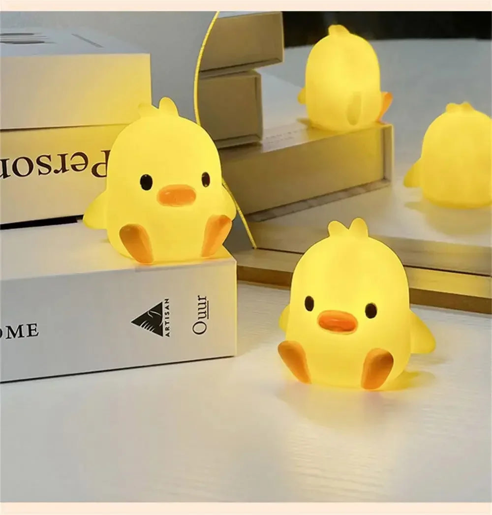 A yellow cartoon duck night light illuminating a room, displayed next to a stack of boxes.