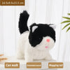A white and black plush cat toy with a black tail and pink nose, demonstrating walking and wagging features.