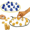 Une main place des pièces d'un jeu de stratégie magnétique sur un cercle jaune, avec plusieurs pièces éparpillées.