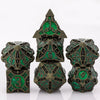 A set of seven metal dice featuring a skull and dragon design in dark bronze and green enamel.