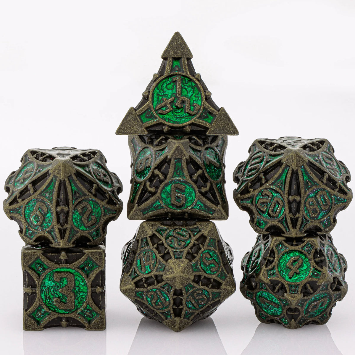 A set of seven metal dice featuring a skull and dragon design in dark bronze and green enamel.