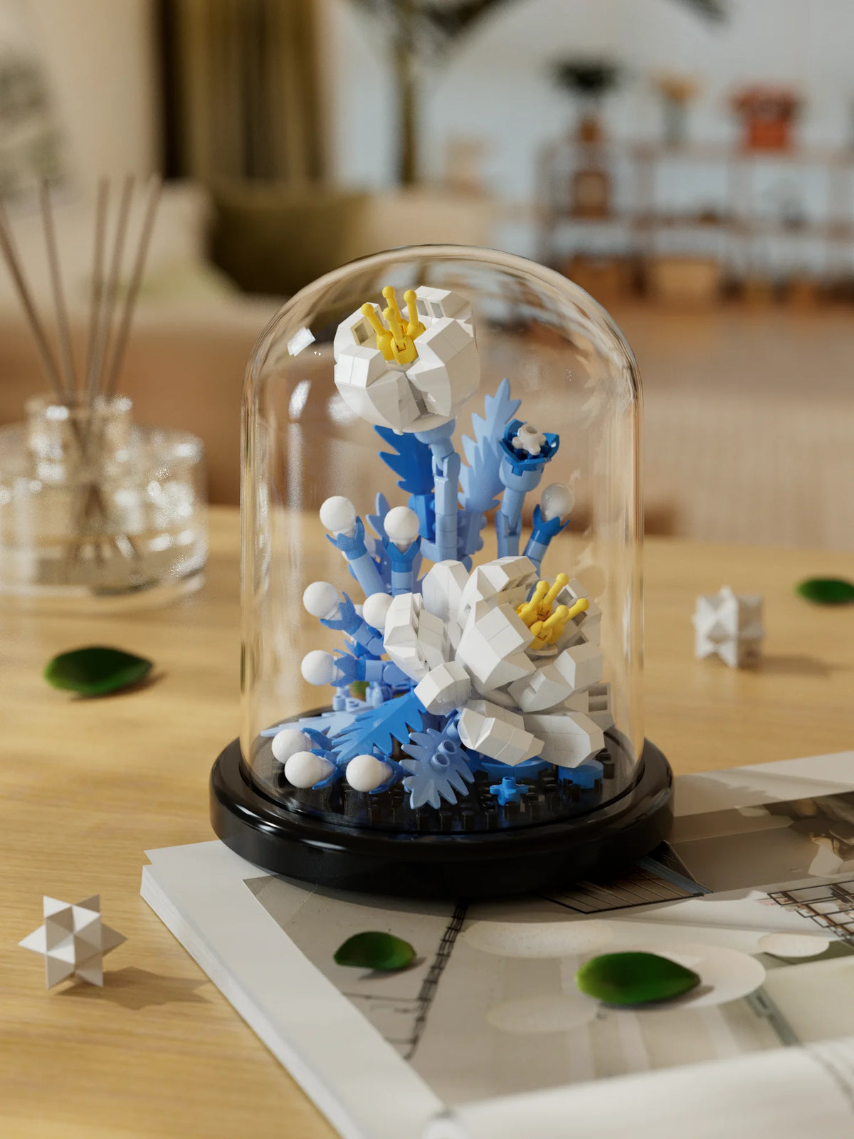 A glass dome display of a buildable eternal rose flower kit featuring white and blue floral elements.
