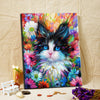 A vibrant paint by numbers canvas featuring a fluffy black and white kitten face surrounded by colorful floral scenery.