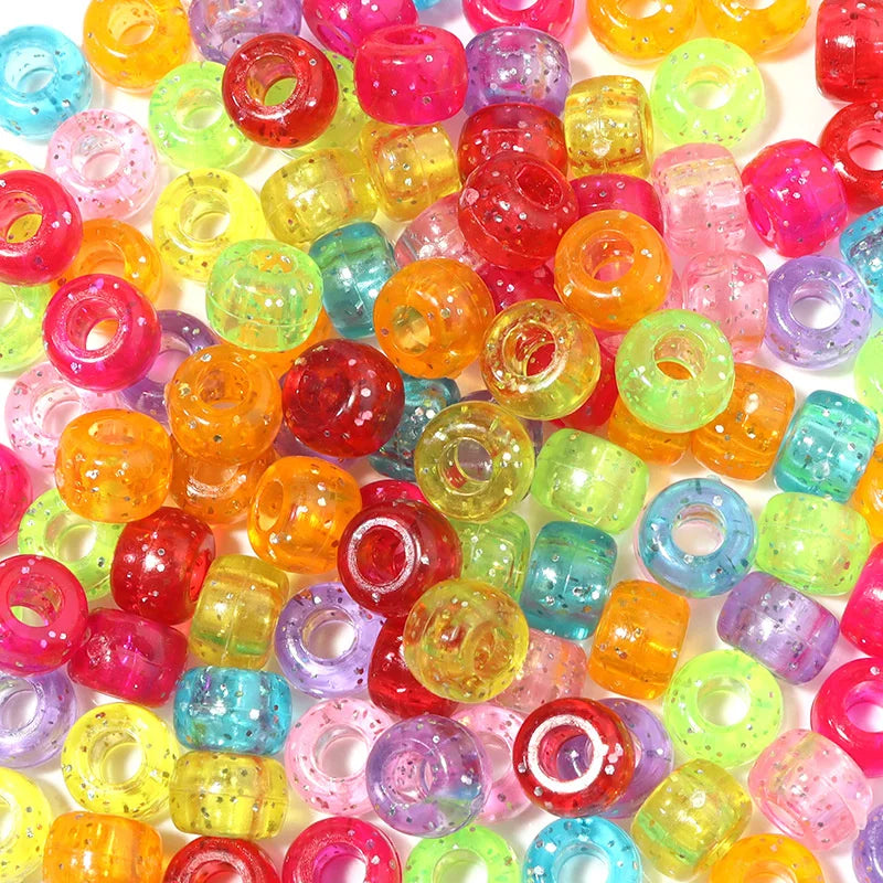 A large collection of colorful, translucent pony beads in various shades including pink, orange, yellow, green, and purple.