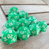 A collection of ten green pearl acrylic D20 dice scattered on a wooden surface.