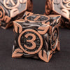 A close-up of a bronze metal die with the number 3 engraved on its face, set against a dark background.