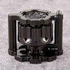 A black revolver-shaped metal dice set for RPG games resting on a gray surface.
