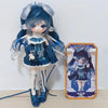 An articulated doll with blue hair and clothing is displayed next to its packaging box.
