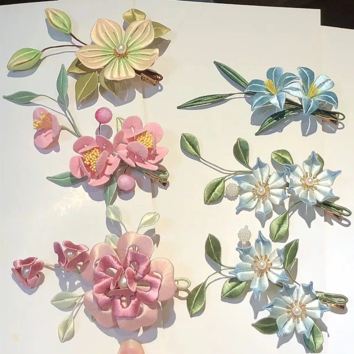 A collection of twenty-color metal watercolor paint flowers in various shades of pink, blue, and green.