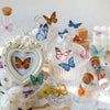 A collection of whimsical butterfly stickers in various colors and sizes displayed on a rustic surface.