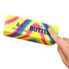 A yellow squishy butter stick fidget toy with a rainbow gradient design is held by a hand.