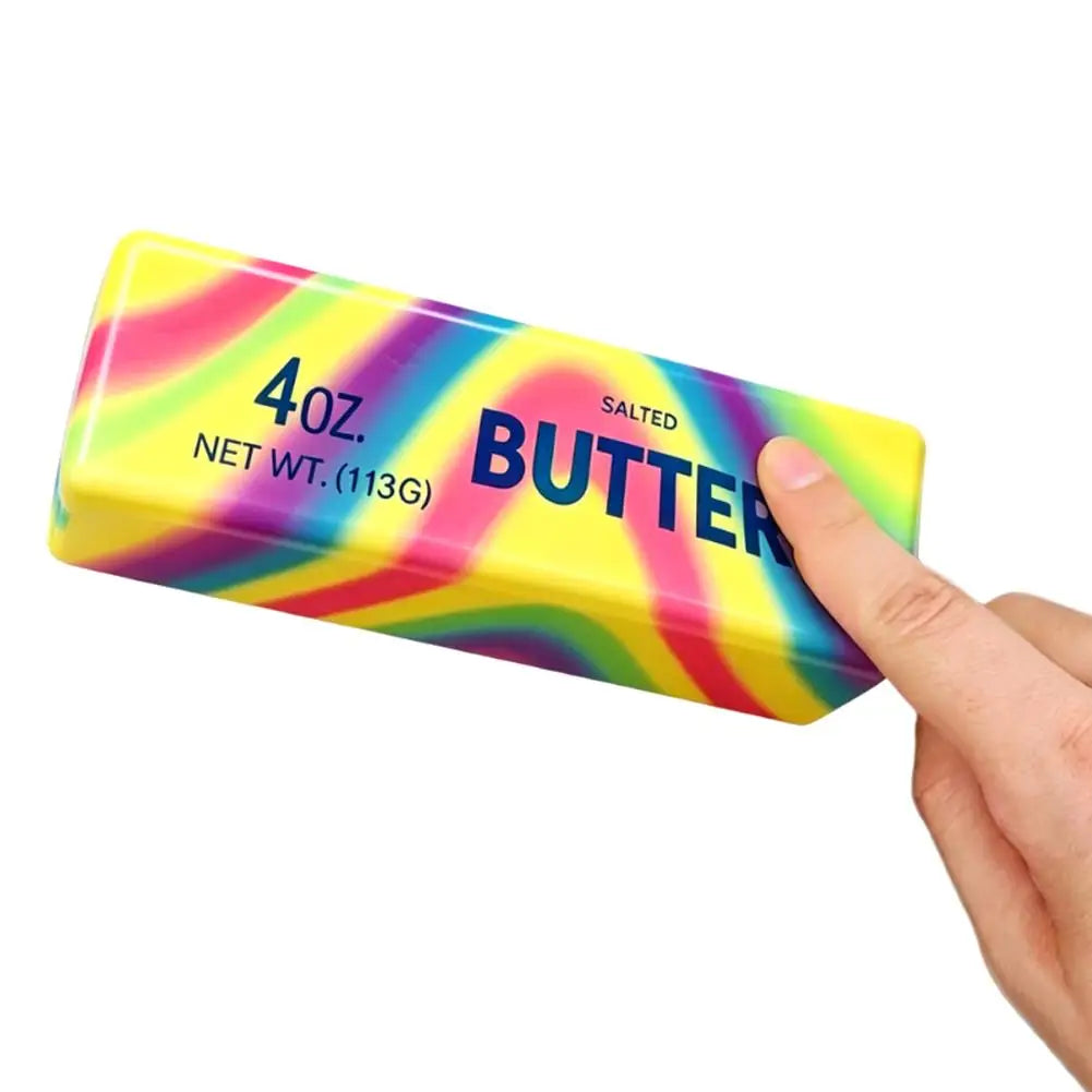 A yellow squishy butter stick fidget toy with a rainbow gradient design is held by a hand.