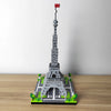 A miniature model of the Eiffel Tower built from gray building blocks on a wooden surface.