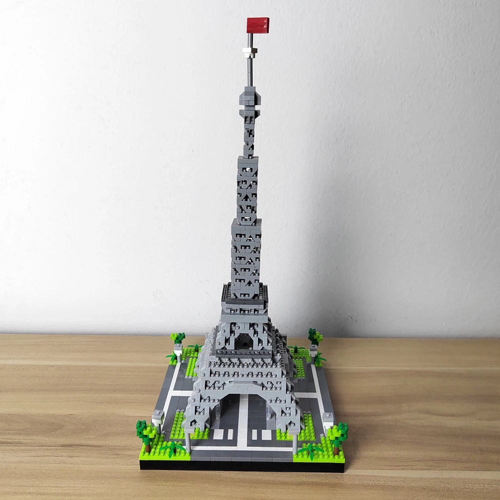 A miniature model of the Eiffel Tower built from gray building blocks on a wooden surface.