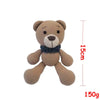 A handmade crochet stuffed bear toy in a light brown color with dark blue accents.