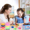 A young girl is playing with a set of 24-color ultra light modeling clay, featuring various colored molds and tools.