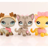 A set of three LPS-style vinyl cat figurines in shades of gray, pink, and yellow with accessories.