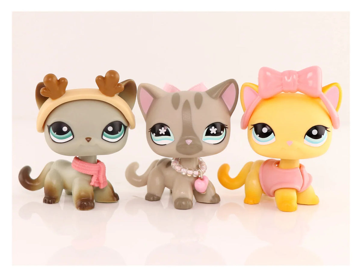 A set of three LPS-style vinyl cat figurines in shades of gray, pink, and yellow with accessories.