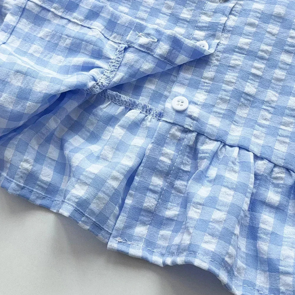 A close-up of a light blue and white checkered lace vest and wide-leg pants set.