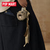 A dark navy coat features a fluffy bear keychain with a striped fabric tag attached to the lapel.