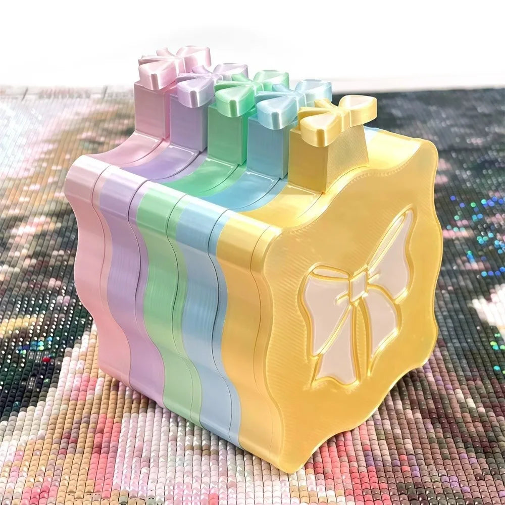 A plastic organizer tray for diamond painting supplies featuring multiple compartments and a lid in pastel colors.