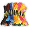 A collection of multicolor embroidery floss skeins in various shades including orange, pink, blue, and green.