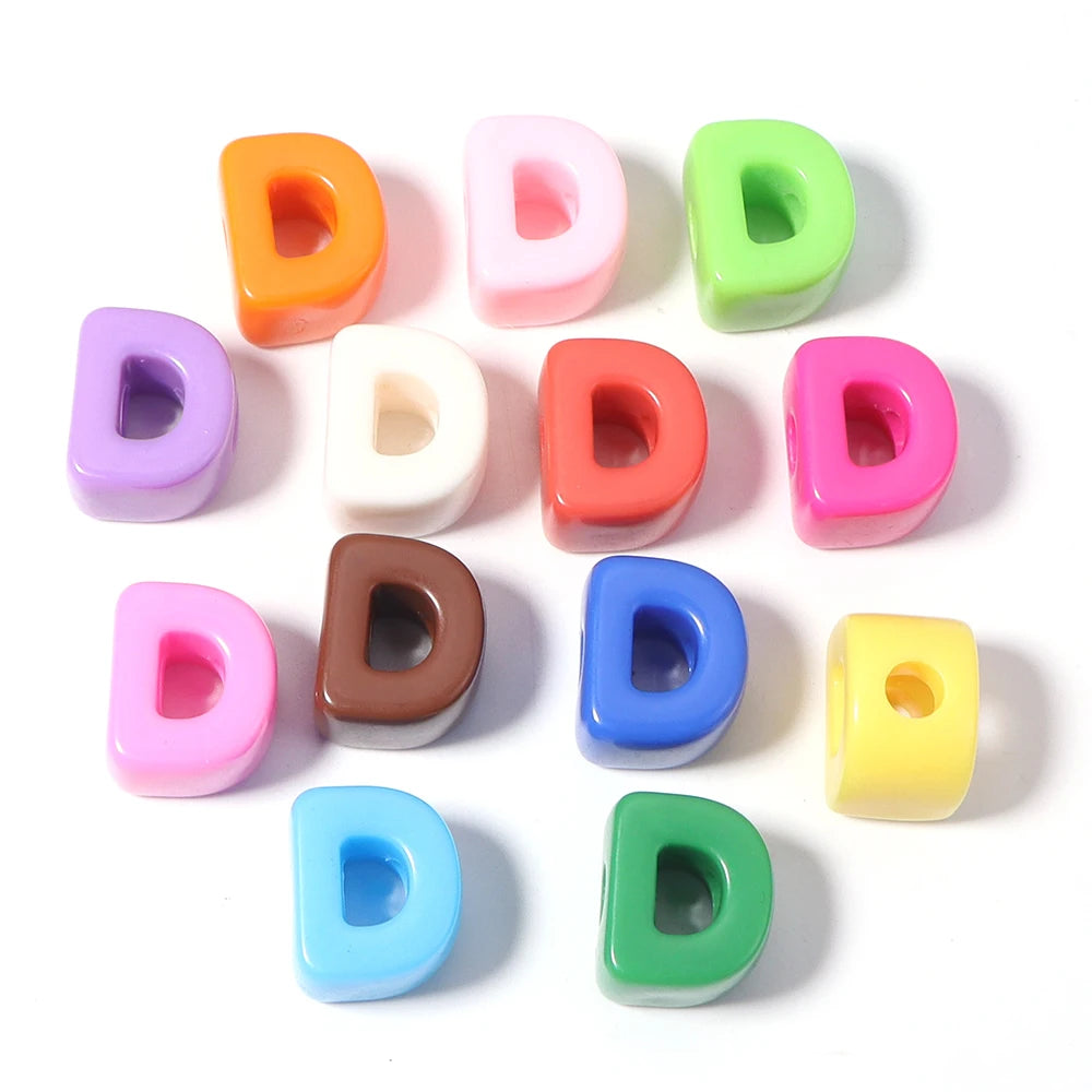 A collection of colorful acrylic alphabet beads in various shades including orange, pink, green, purple, and yellow.