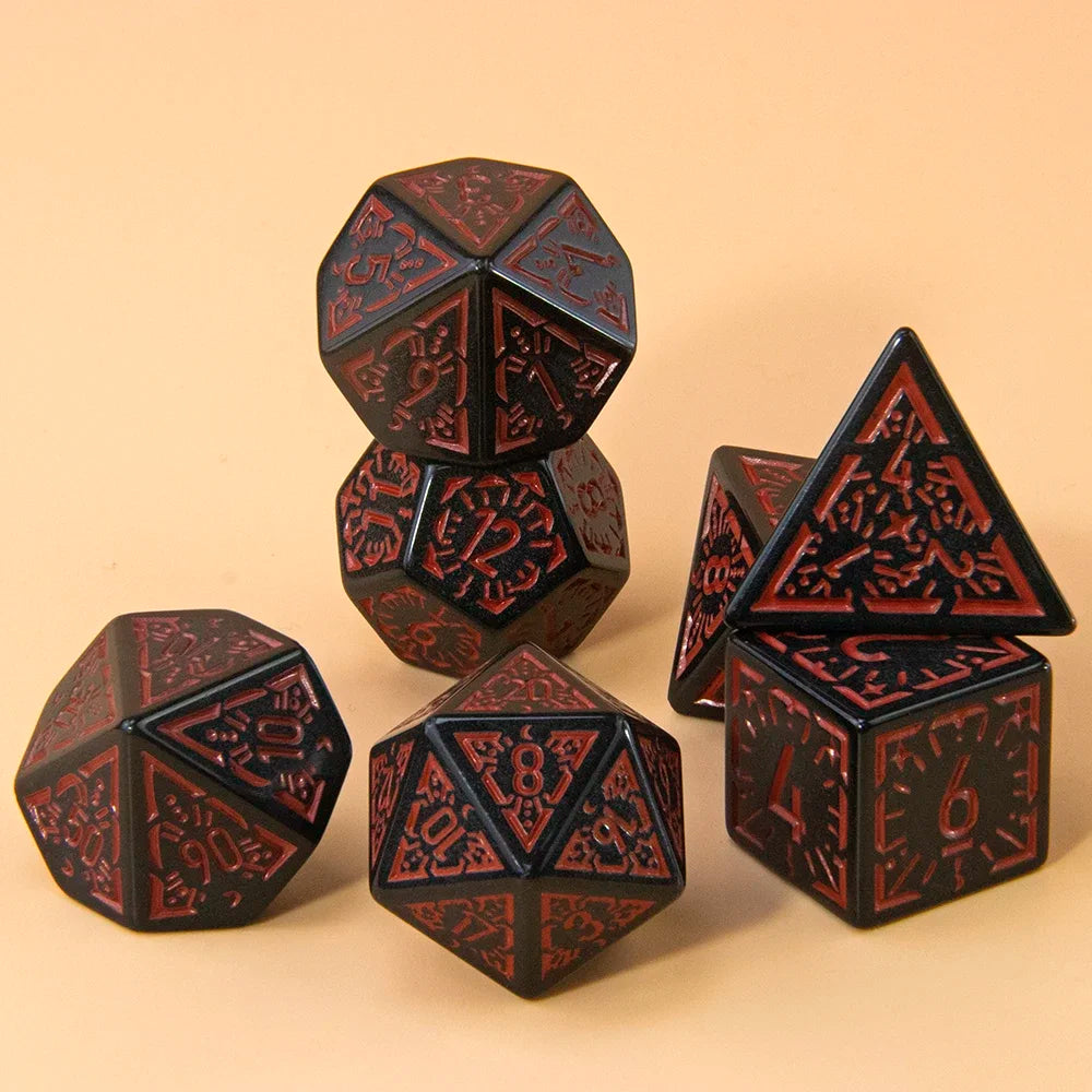 A set of seven polyhedral dice in black and red are arranged on a light brown surface.
