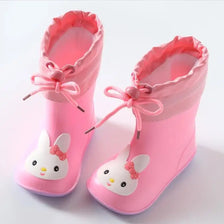 A pair of pink kids rain boots featuring cute white rabbit designs and pink laces.