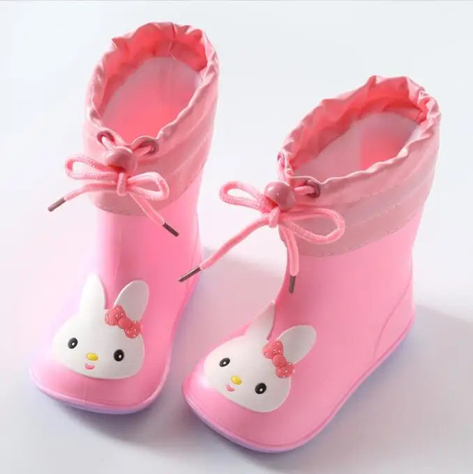 A pair of pink kids rain boots featuring cute white rabbit designs and pink laces.