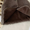 A close-up of a brown and gray fuzzy lamb wool vest for children, showing the texture and layered design.