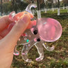 A hand holds a clear squishy ocean octopus fidget toy with pink and black accents outdoors.